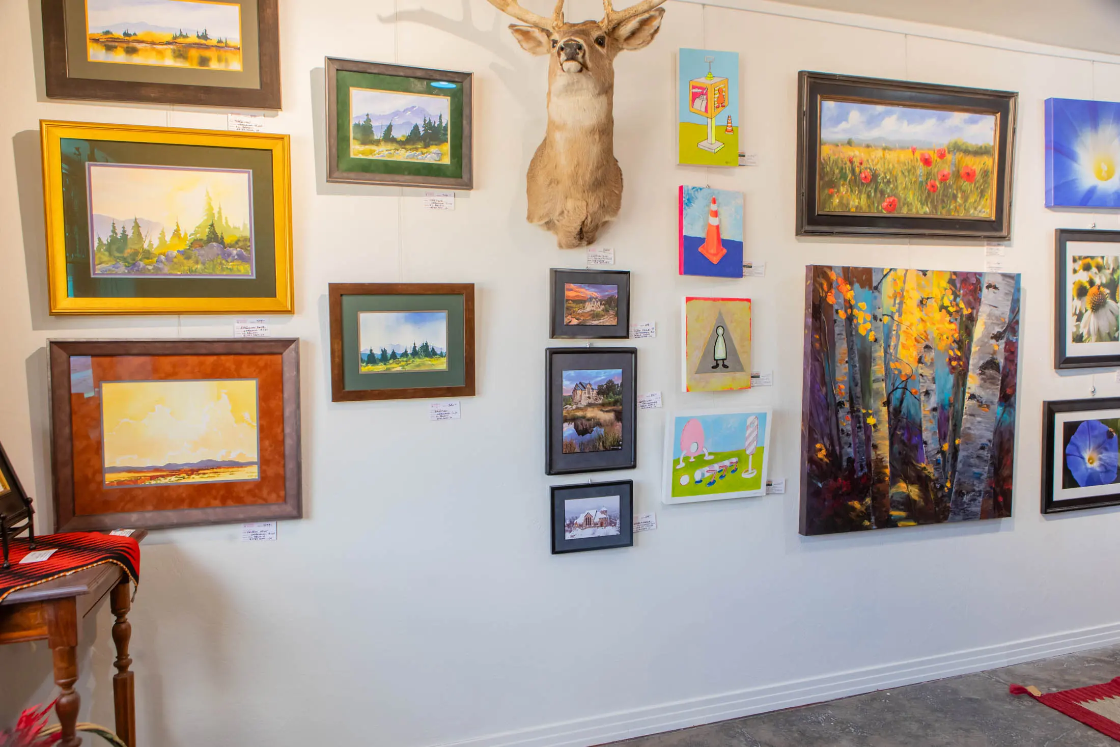 Colorful gallery wall with mounted deer head