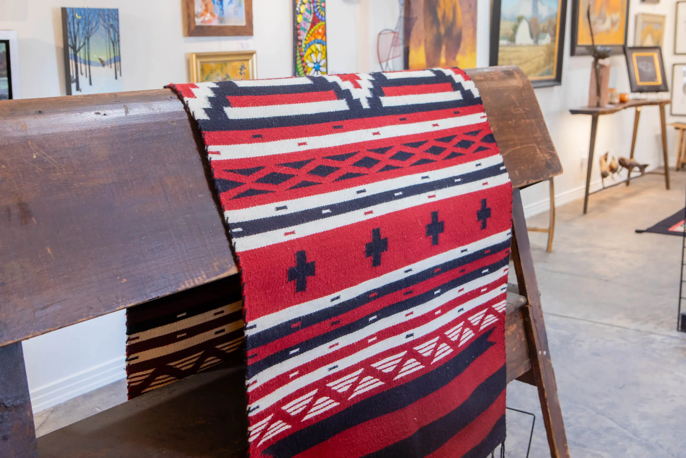 Red geometric patterned blanket on wooden bench